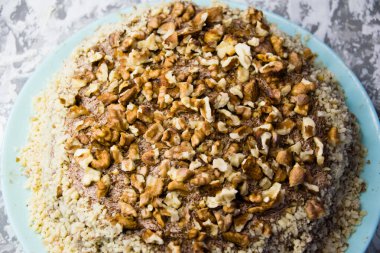 Hafif arka planda kremalı, fıstıklı ve cevizli nefis ev yapımı kek. Doğal ev yapımı pişirme kavramı.