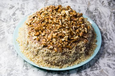 Hafif arka planda kremalı, fıstıklı ve cevizli nefis ev yapımı kek. Doğal ev yapımı pişirme kavramı.