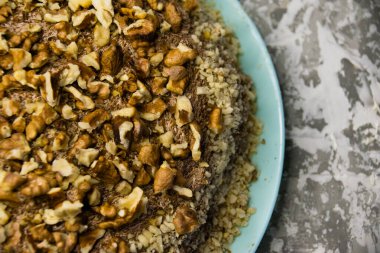 Hafif arka planda kremalı, fıstıklı ve cevizli nefis ev yapımı kek. Doğal ev yapımı pişirme kavramı.