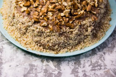 Hafif arka planda kremalı, fıstıklı ve cevizli nefis ev yapımı kek. Doğal ev yapımı pişirme kavramı.