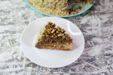 Hafif arka planda kremalı, fıstıklı ve cevizli nefis ev yapımı kek. Beyaz bir tabakta iştah açıcı bir pasta. Doğal ev yapımı pişirme kavramı.