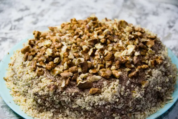 Hafif arka planda kremalı, fıstıklı ve cevizli nefis ev yapımı kek. Doğal ev yapımı pişirme kavramı.