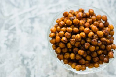 Şeffaf bir kasede şeffaf bir arkaplanda pişmiş bezelyeler ve düz yazı için yer var. Sağlıklı yeme kavramı