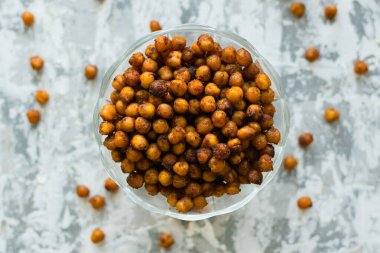 Masanın üzerinde şeffaf bir kâse içinde nefis pişmiş nohutlar, arka planda düz yazı için yer var. Sağlıklı yeme kavramı