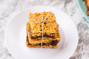 Elma reçelli nefis ev yapımı turta. Aperatif rendelenmiş turta dilimleri ve beyaz bir tabakta reçel..