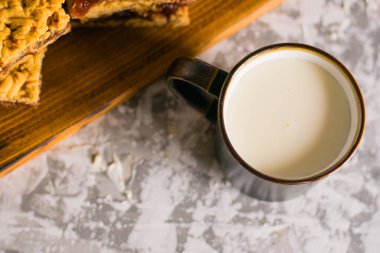 Elma reçelli nefis ev yapımı turta. İştah açıcı rendelenmiş turta dilimleri, ahşap bir tahtada reçel ve bir bardak süt.