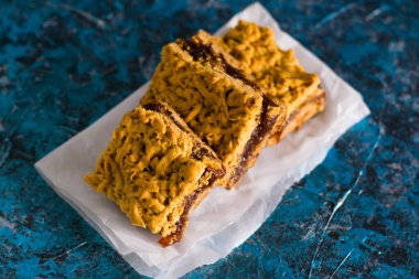 Elma reçelli nefis ev yapımı turta. Parşömen kağıdına reçel sürülmüş, elmalı ve tarçınlı turta parçaları..