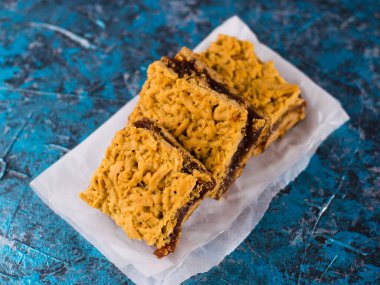 Elma reçelli nefis ev yapımı turta. Parşömen kağıdına reçel sürülmüş, elmalı ve tarçınlı turta parçaları..