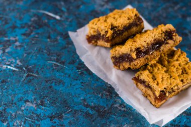 Elma reçelli nefis ev yapımı turta. Parşömen kağıdına reçel sürülmüş, elmalı ve tarçınlı turta parçaları..