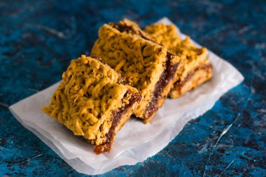 Elma reçelli nefis ev yapımı turta. Parşömen kağıdına reçel sürülmüş, elmalı ve tarçınlı turta parçaları..