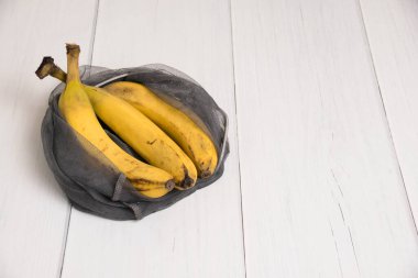 Hafif bir arka planda eko-torba içinde bozulmuş muzlar.