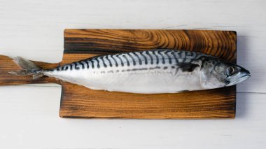 Kesme tahtasındaki çiğ uskumru balığı, balık pişirme..