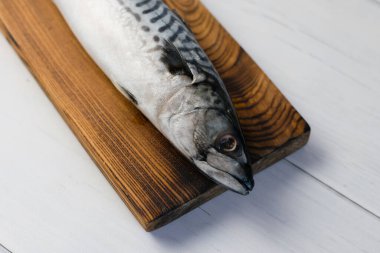 Kesme tahtasındaki çiğ uskumru balığı, balık pişirme..