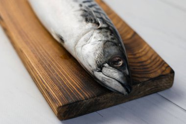 Kesme tahtasındaki çiğ uskumru balığı, balık pişirme..