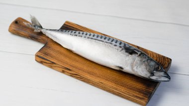 Kesme tahtasındaki çiğ uskumru balığı, balık pişirme..