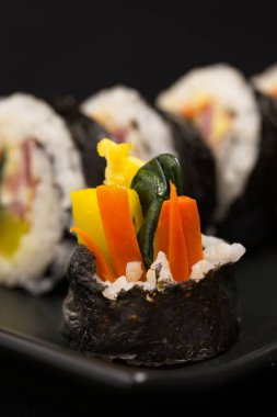 Kimbap adında bir Kore ikramının son parçası. Buharda pilav, deniz yosunu, havuç, ıspanak, yumurta ve turşu turşusundan yapılan yemekler..