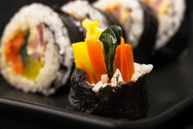 Kimbap adında bir Kore ikramının son parçası. Buharda pilav, deniz yosunu, havuç, ıspanak, yumurta ve turşu turşusundan yapılan yemekler..