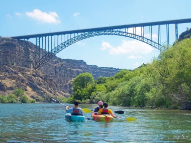 Twin Falls, Idaho 'daki Perrine Köprüsü' nün yakınındaki Snake River 'da tatil yapan bir aile kano yapıyor..