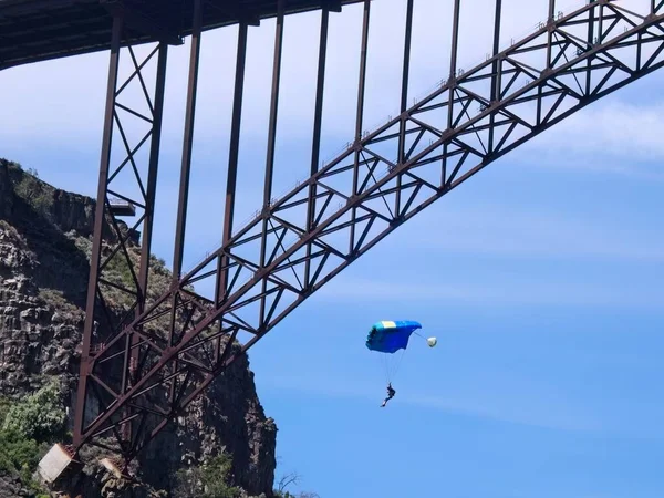 爱达荷州特温福尔斯的佩琳桥旁边 一名跳伞跳投手滑翔在降落伞下 — 图库照片