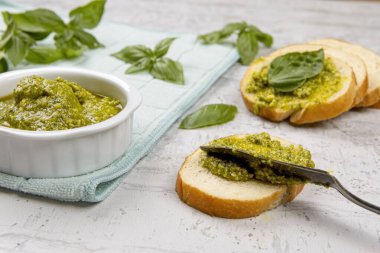 Stüdyoda küçük dilimlere taze pesto serpiştirirken çekilmiş bir fotoğraf..