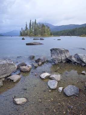 Wenatchee Gölü kıyısındaki kayalar kara bulutlu gökyüzünün altında.