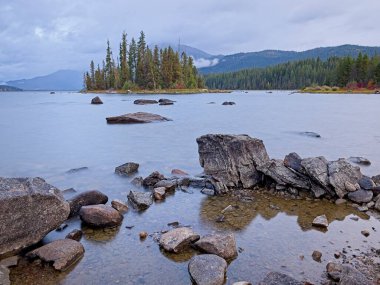 Wenatchee Gölü kıyısındaki kayalar kara bulutlu gökyüzünün altında.