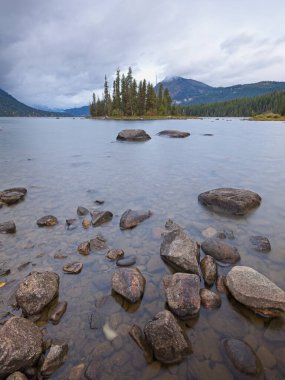 Wenatchee Gölü kıyısındaki kayalar kara bulutlu gökyüzünün altında.