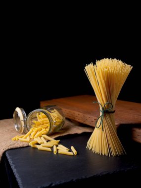 Kurutulmuş makarna, ayakta duran makarna ve cam kavanozdan dökülen makarna..