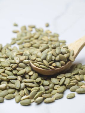 Ahşap bir kaşık ve masanın üzerinde kavrulmuş kabak tohumlarının yakın çekim fotoğrafı..