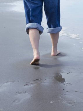 Washington 'da Pasifik Okyanusu kıyısında çıplak ayakla yürüyen bir kadının yakın konsept fotoğrafları..