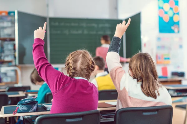 Two Girl Students Raising Hands Answer Question School Class Because — Stock Photo, Image