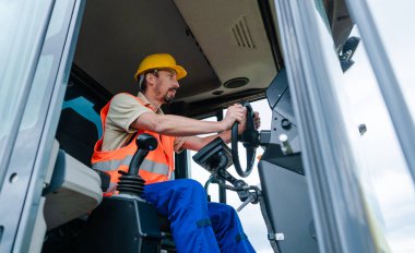 Şantiyede yapılacak işi planlayan ekskavatör üzerinde inşaat işçisi