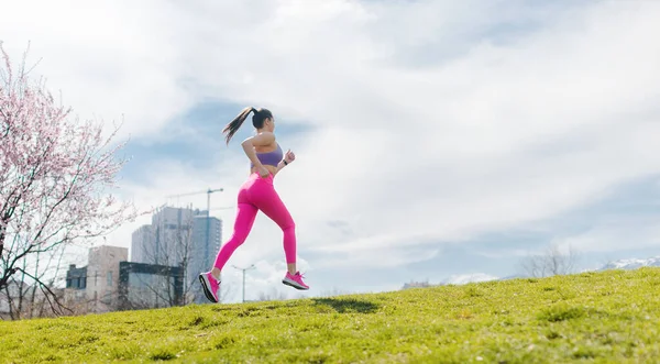 女人在山上跑步以锻炼身体 作为城市面前的一项运动 — 图库照片