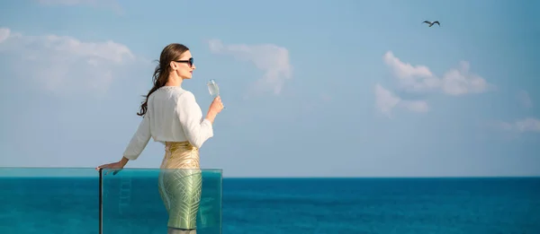 Γυναίκα Απολαμβάνοντας Ποτήρι Σαμπάνιας Στο Στέκεται Στη Θάλασσα Στη Βεράντα — Φωτογραφία Αρχείου