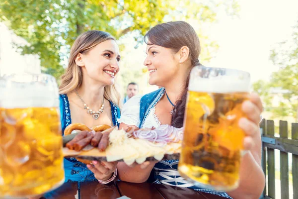 Dwie Dziewczyny Tracht Jedzeniem Piciem Ogrodzie Piwnym — Zdjęcie stockowe