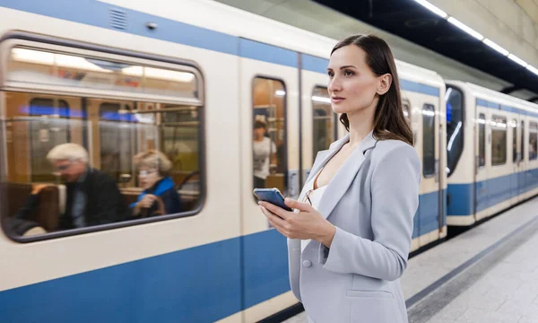 Женщина Костюме Телефоном Руке Станции Метро Прибывающим Поездом — стоковое фото