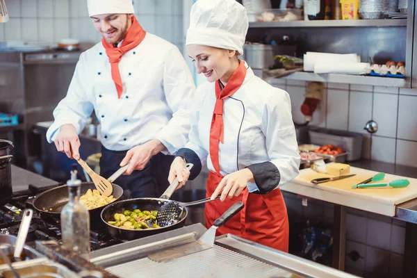 요리사 여자와 남자가한 팀으로 주방에서 요리하는 스톡 이미지