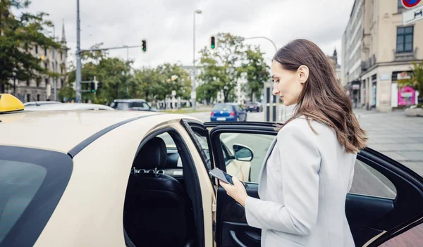 Wanita Bisnis Mengenakan Jas Memasuki Taksi Kota Stok Gambar