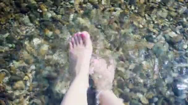 在一个炎热 阳光灿烂的日子里 一个女人的脚步声在冷水中打转 形成了水花 — 图库视频影像