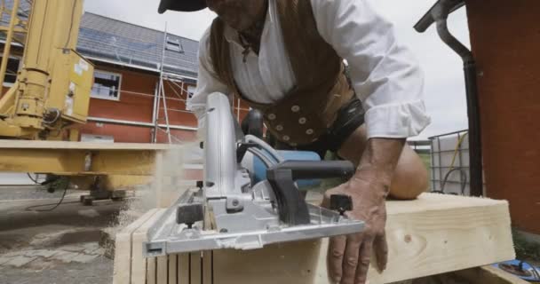 Cieśla Placu Budowy Przecinający Drewnianą Belkę Piłą Elektryczną — Wideo stockowe