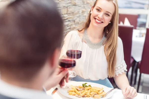 情侣们在浪漫餐厅里互相凝视着红酒祝酒 免版税图库照片