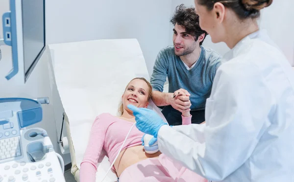 Couple in reproduction clinic being happy as the wife is pregnant as revealed by ultrasonic examination