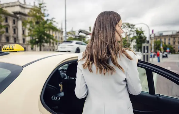 Mujer Negocios Con Traje Que Entra Taxi Ciudad Imagen de archivo