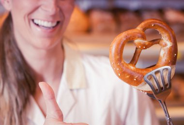 Pastaneci kadın, güler yüzlü bir kraker sunuyor.