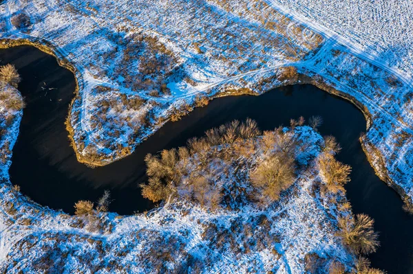 winter aerial top view to river Udy bend in field. Ukraine