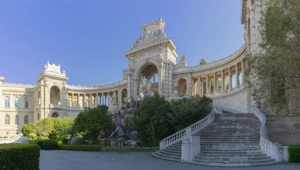 Marsilya 'daki Palais Longchamp görkemli bir ihtişam içinde duruyor. Karmaşık taş kemerleri ve gün ışığının tadını çıkaran büyük merdivenleri. Heykeller ve fıskiyeler bu tarihi anıtı süslüyor, yemyeşil bir parkın içine yerleşmiş, zarafeti yayıyor. 