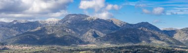 Tramuntana Sıradağları, bulutlu bir gökyüzünün altında, Mallorca 'nın sakin manzarasına bakan görkemli bir yer..