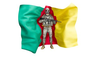 Görüntü, canlı yeşil, kırmızı ve sarı Kamerun bayrağıyla ihtiyatlı bir askerle çarpıcı bir tezat oluşturuyor.