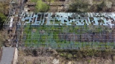 Abandoned industrial greenhouse ruins in spring, aerial view