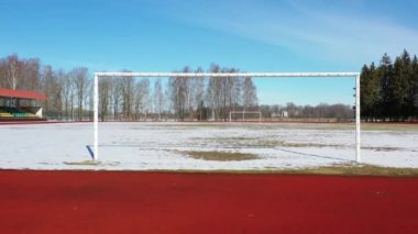 İnsansız hava aracı kışın boş futbol kapısından uçar.